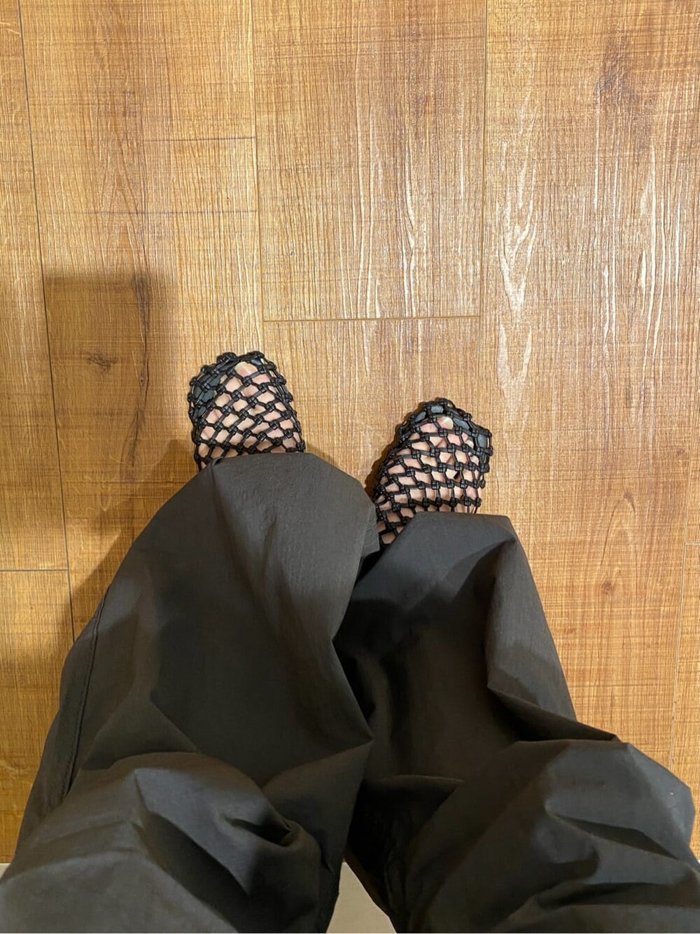 ブラック系のサンダル、ホワイト系のニット/セーター、オレンジ系のシャツ/ブラウスを着用したレディースの春コーディネートの6枚目の写真