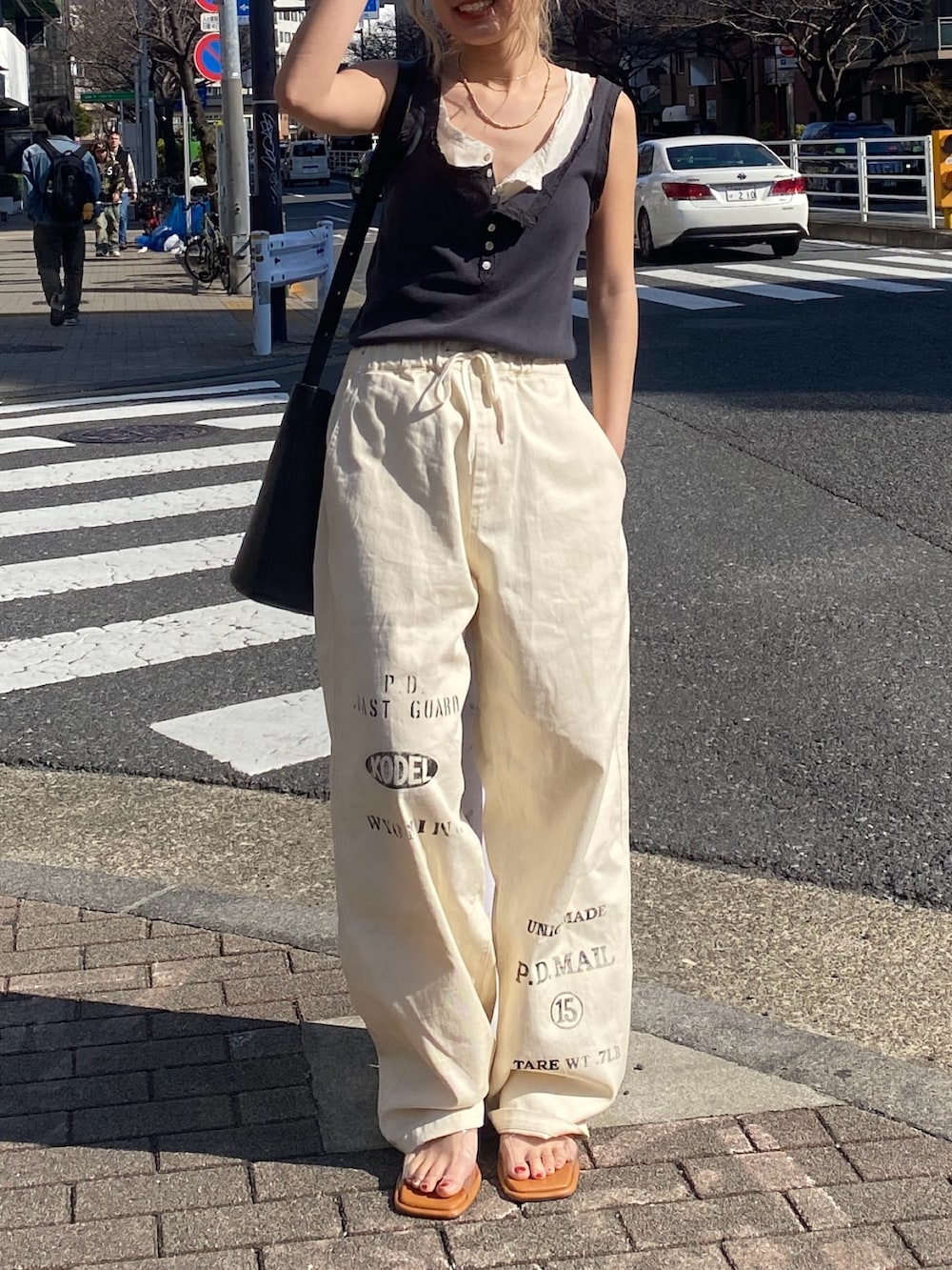 グレー系のタンクトップ、ホワイト系のタンクトップ、ホワイト系のその他パンツを着用したレディースの春コーディネートの4枚目の写真