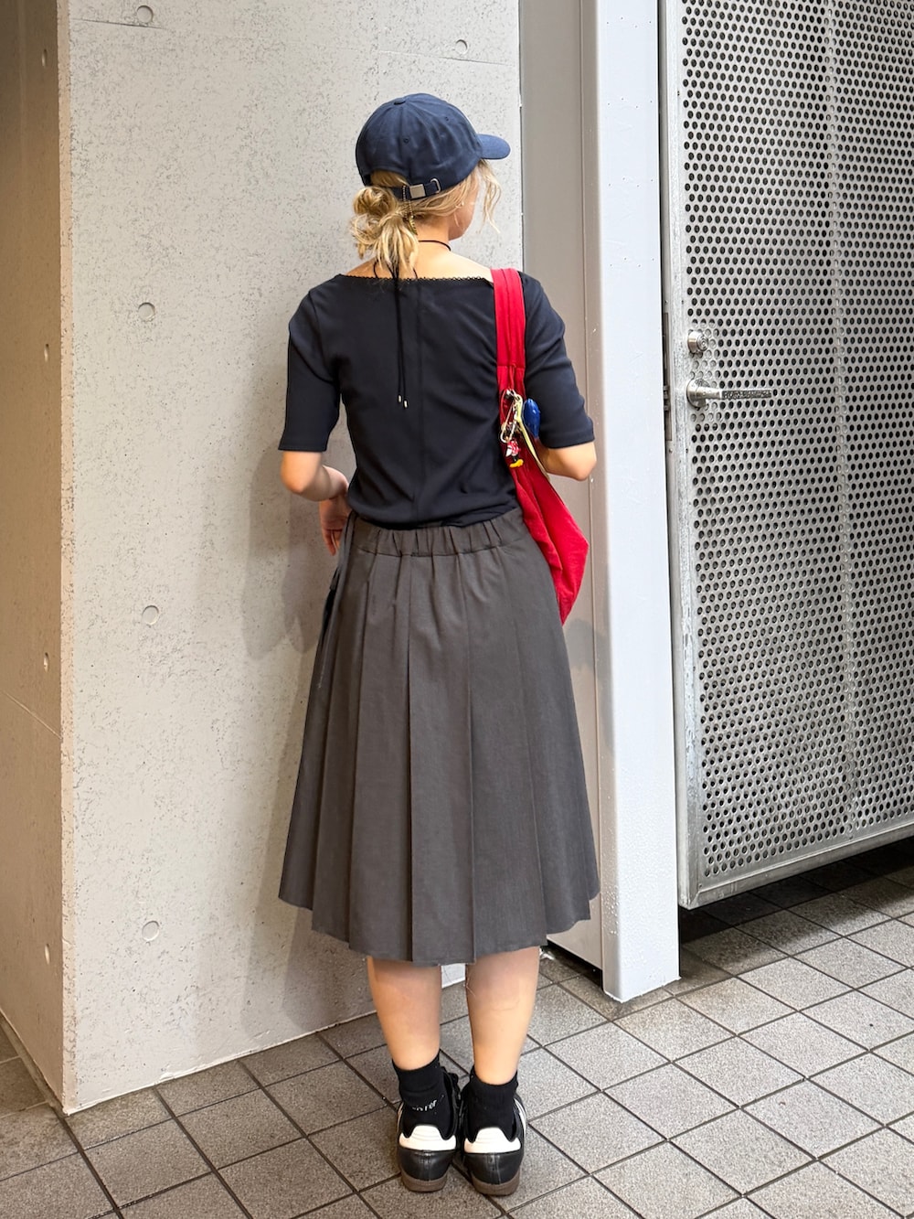 ブラック系のTシャツ/カットソー、レッド系のキャップを着用したレディースの夏コーディネートの4枚目の写真