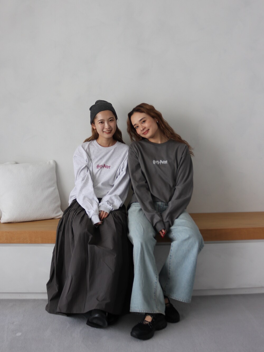 グレー系のTシャツ/カットソー、グレー系のスカート、ブルー系のデニムパンツを着用したレディースの秋コーディネートの5枚目の写真