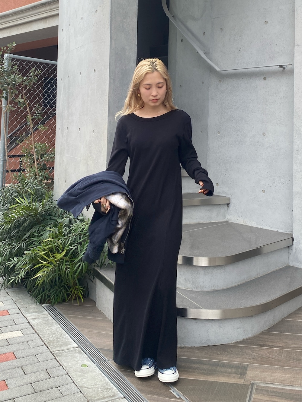 ブラック系のワンピース、ブルー系のスニーカーを着用したレディースの冬コーディネートの3枚目の写真