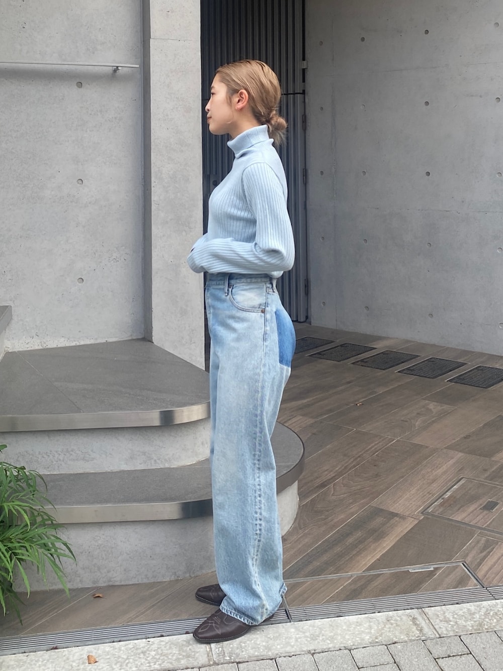 ブルー系のニット/セーター、ブルー系のデニムパンツ、ブラウン系のその他シューズを着用したレディースの秋コーディネートの2枚目の写真
