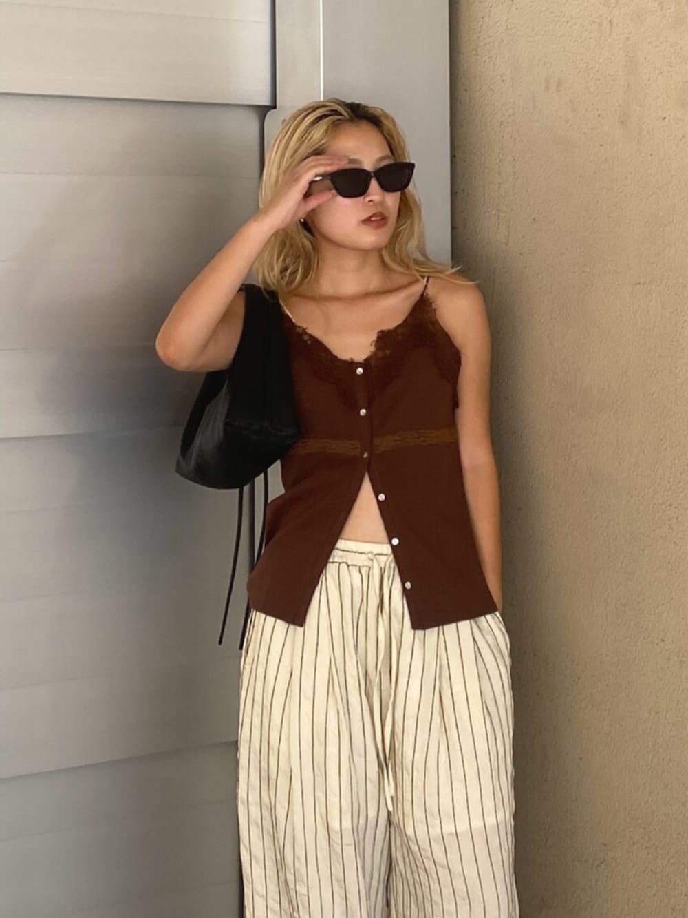 ホワイト系のその他パンツ、ブラウン系のTシャツ/カットソー、ブラック系のハンドバッグを着用したレディースの夏コーディネートの5枚目の写真