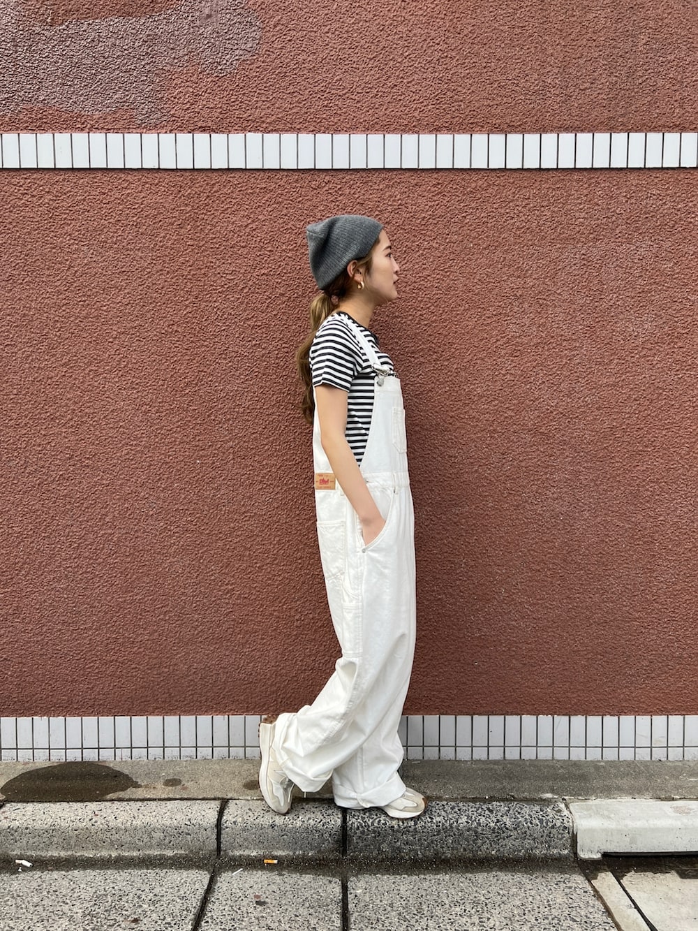 ホワイト系のつなぎ/オールインワン、グレー系のTシャツ/カットソー、グレー系のニットキャップ/ビーニーを着用したレディースの春コーディネートの2枚目の写真