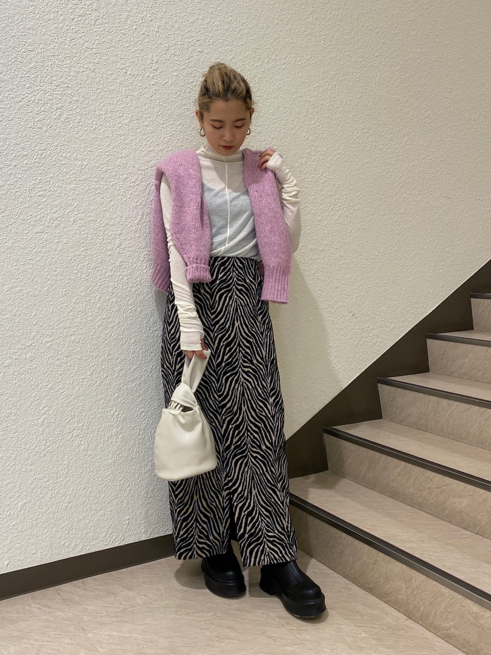 ピンク系のカーディガン/ボレロ、ホワイト系のTシャツ/カットソー、ブラック系のスカートを着用したレディースの秋コーディネートの4枚目の写真