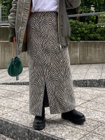 グリーン系のMA-1、レッド系のニット/セーター、ホワイト系のTシャツ/カットソーを着用したレディースの秋コーディネートの7枚目の写真