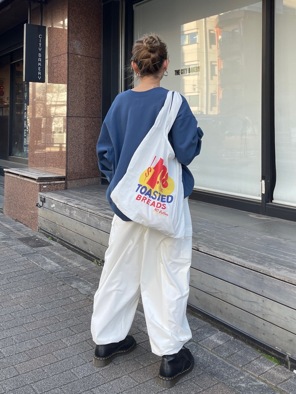ホワイト系のカーゴパンツ、ブルー系のスウェット、ホワイト系のエコバッグ/サブバッグを着用したレディースの冬コーディネートの3枚目の写真