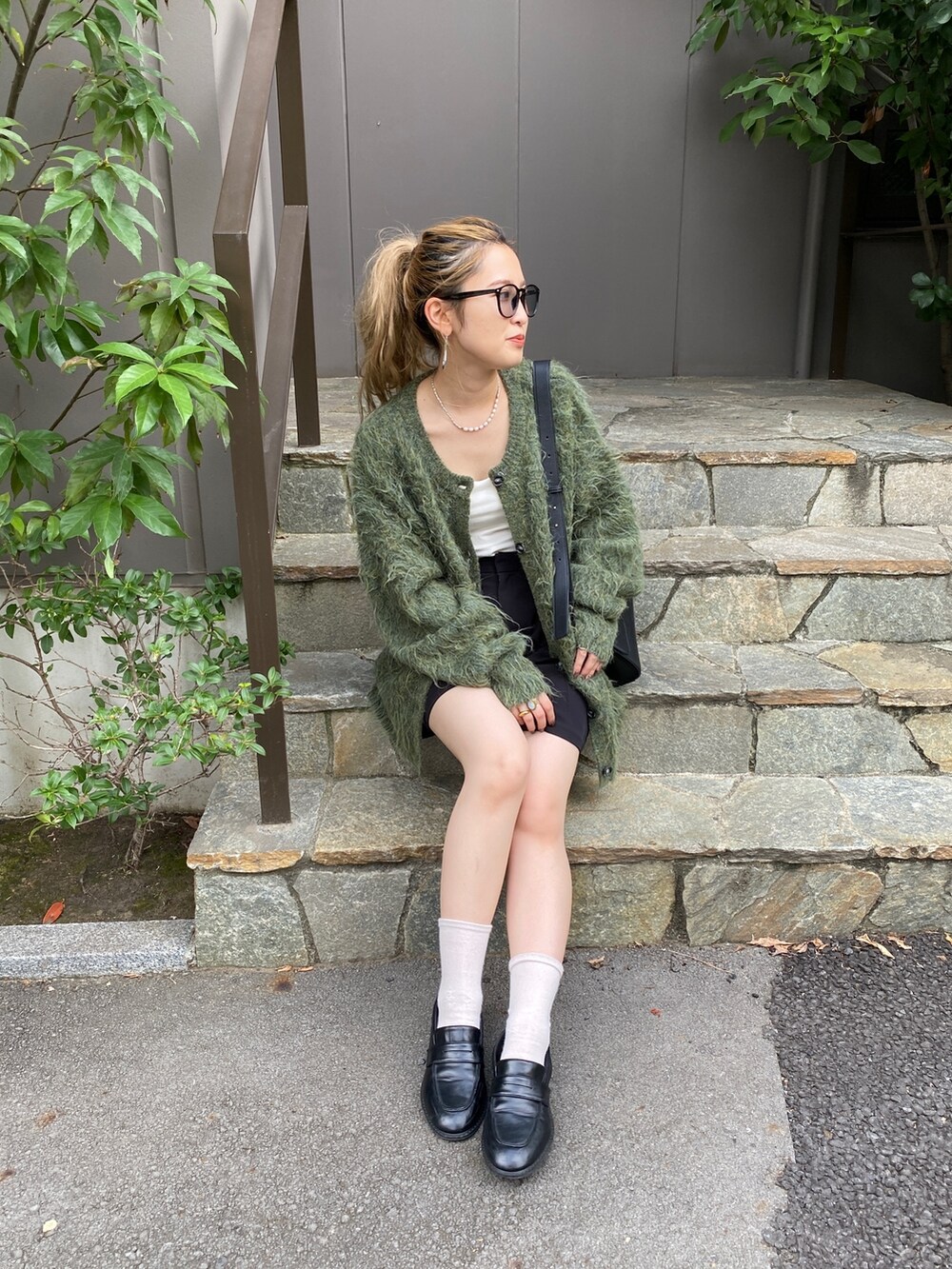 グリーン系のカーディガン/ボレロ、ブラック系のショルダーバッグ、ブラック系のローファーを着用したレディースの秋コーディネートの5枚目の写真