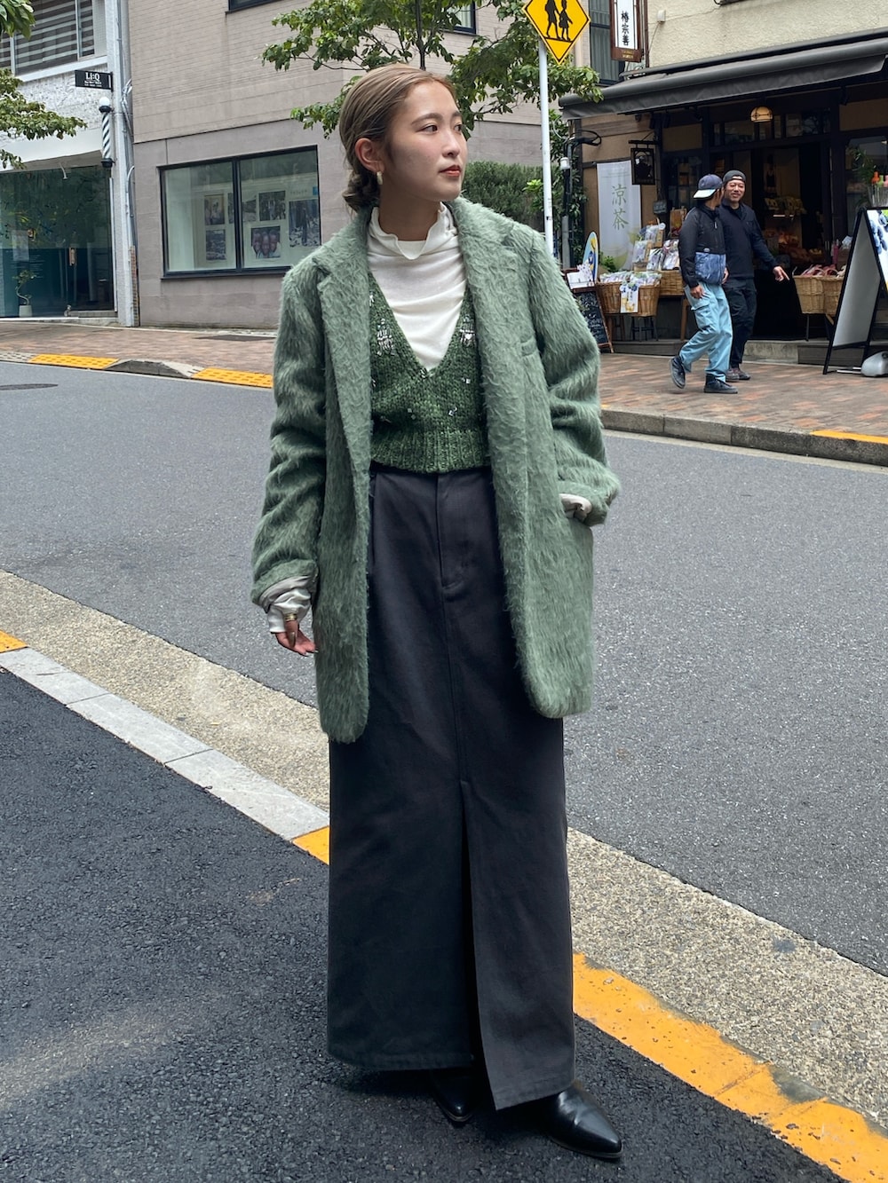 グリーン系のベスト、ホワイト系のTシャツ/カットソー、グリーン系のテーラードジャケットを着用したレディースの秋コーディネートの2枚目の写真