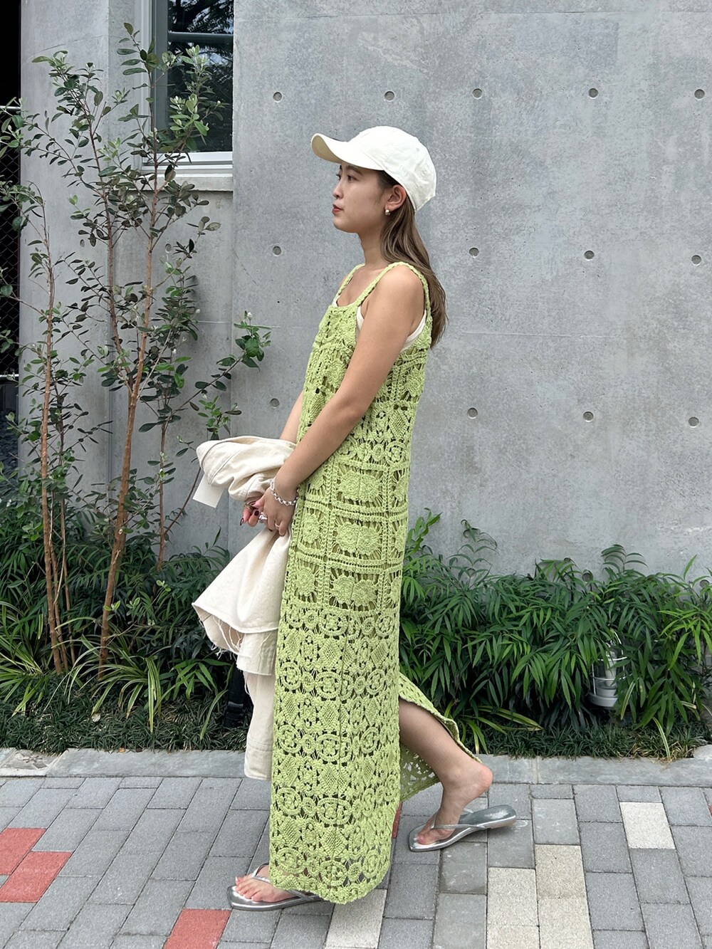 グリーン系のワンピース、ホワイト系のシャツ/ブラウス、ホワイト系のキャップを着用したレディースの春コーディネートの3枚目の写真