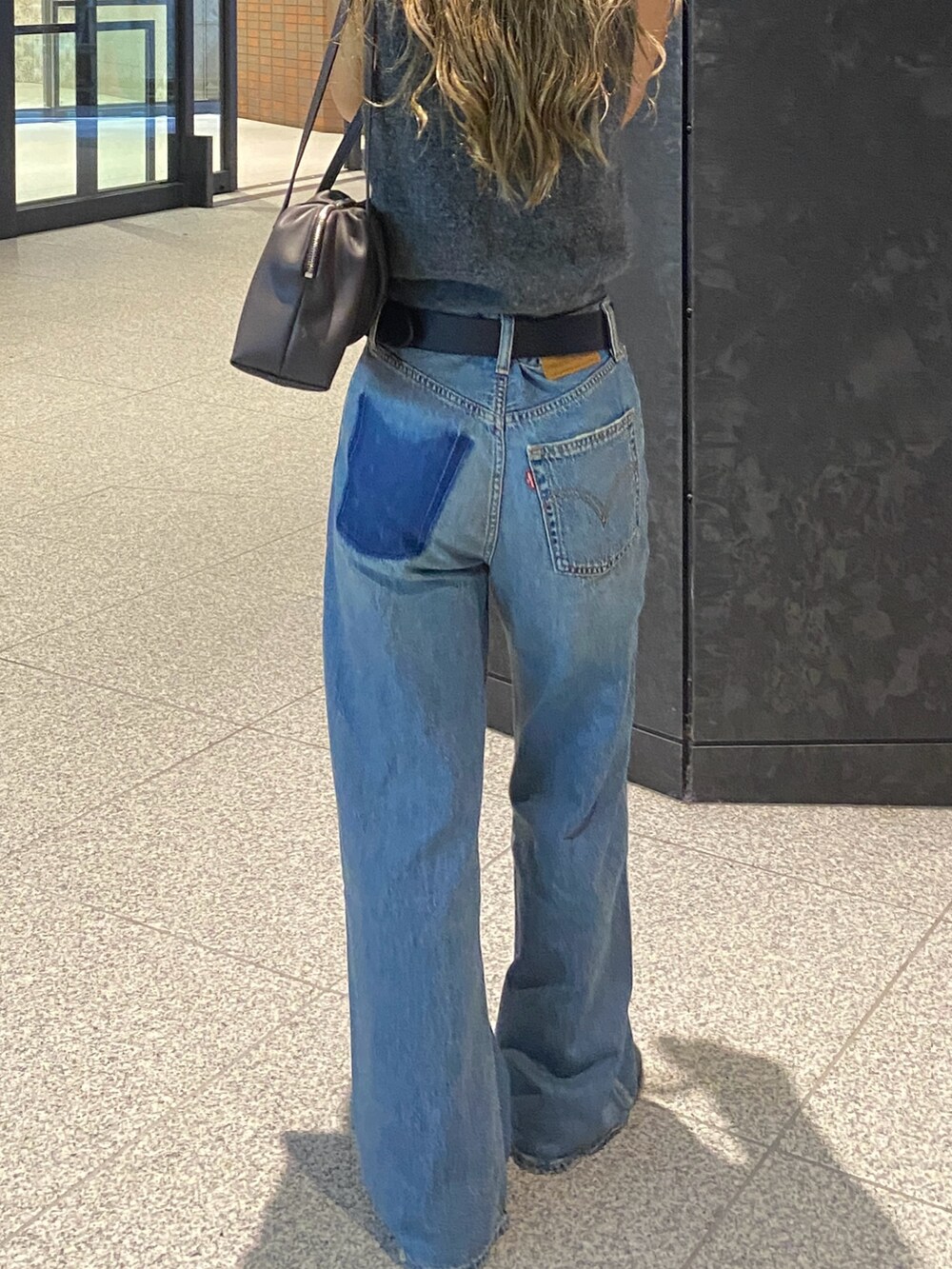 ブルー系のデニムパンツを着用したレディースの秋コーディネートの2枚目の写真