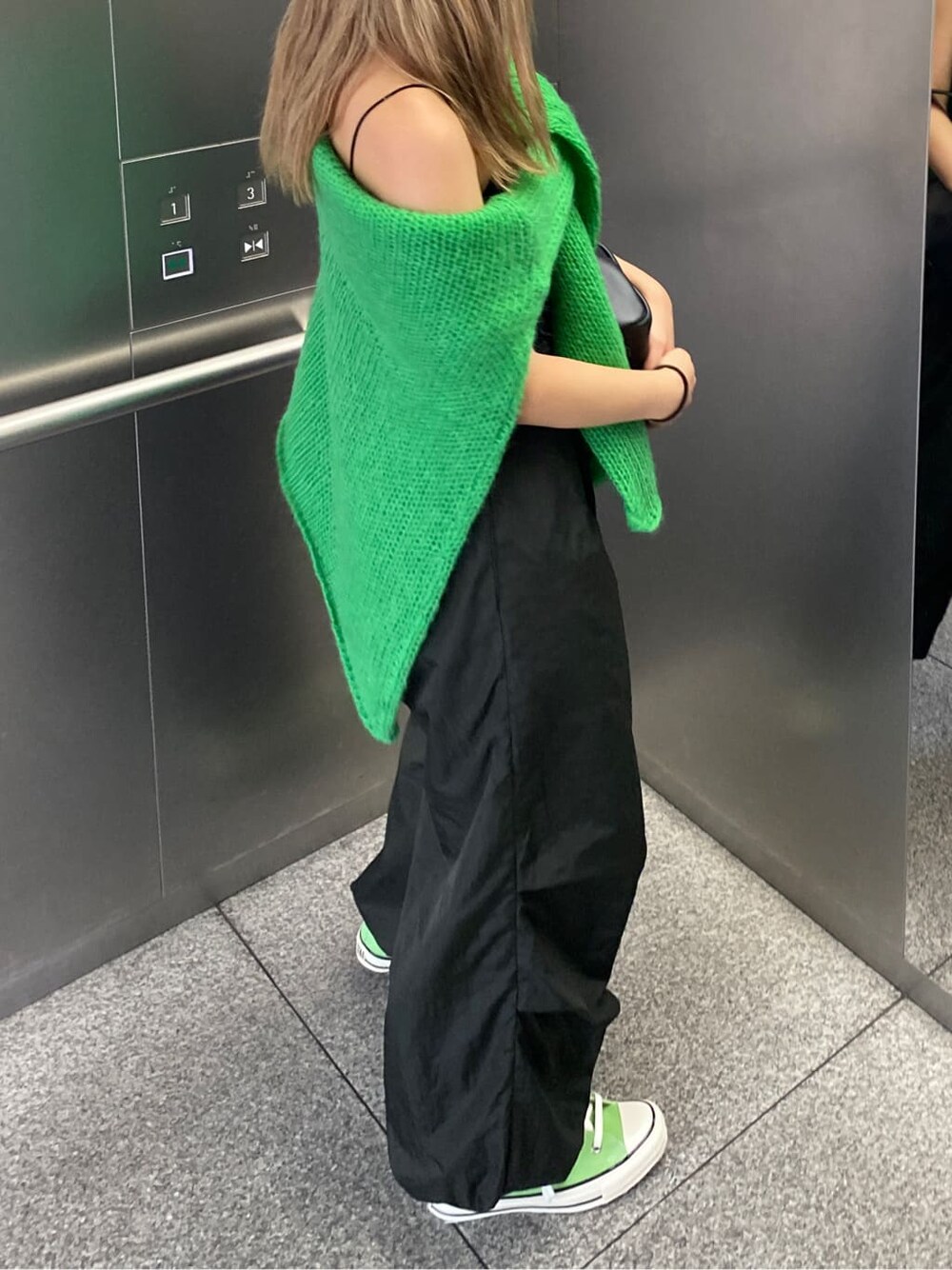 グリーン系のニット/セーター、グレー系のその他パンツを着用したレディースの秋コーディネートの3枚目の写真