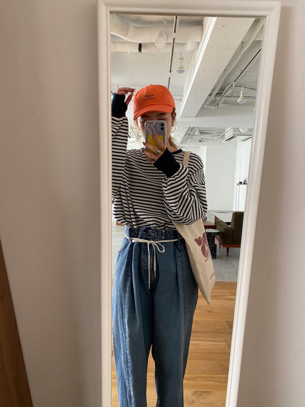 ブルー系のTシャツ/カットソー、ブルー系のデニムパンツ、レッド系のトートバッグを着用したレディースの冬コーディネートの5枚目の写真