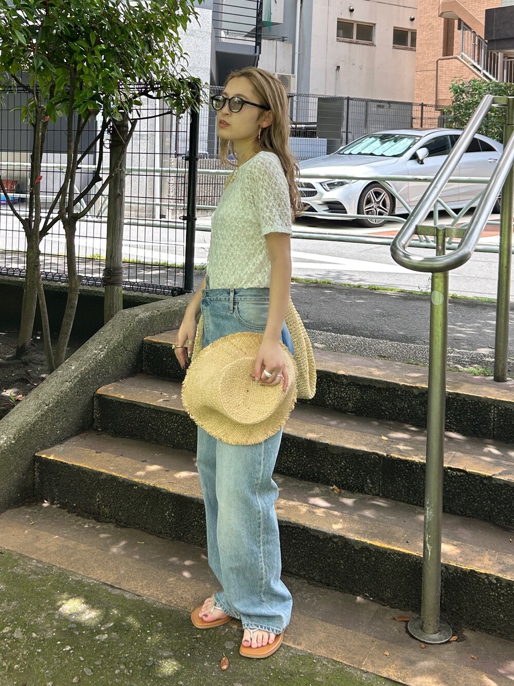 ホワイト系のTシャツ/カットソー、ブルー系のデニムパンツ、ベージュ系のハットを着用したレディースの夏コーディネートの3枚目の写真