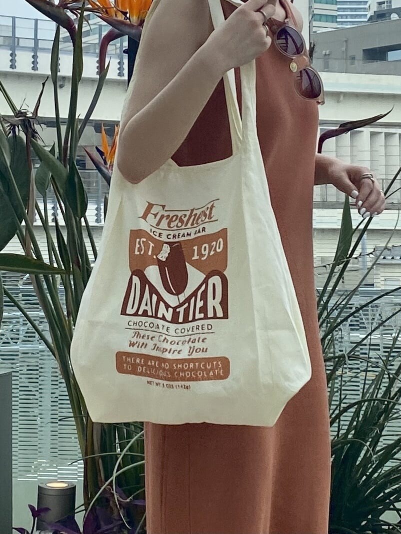 イエロー系のエコバッグ/サブバッグ、ブラウン系のワンピースを着用したレディースの夏コーディネートの3枚目の写真