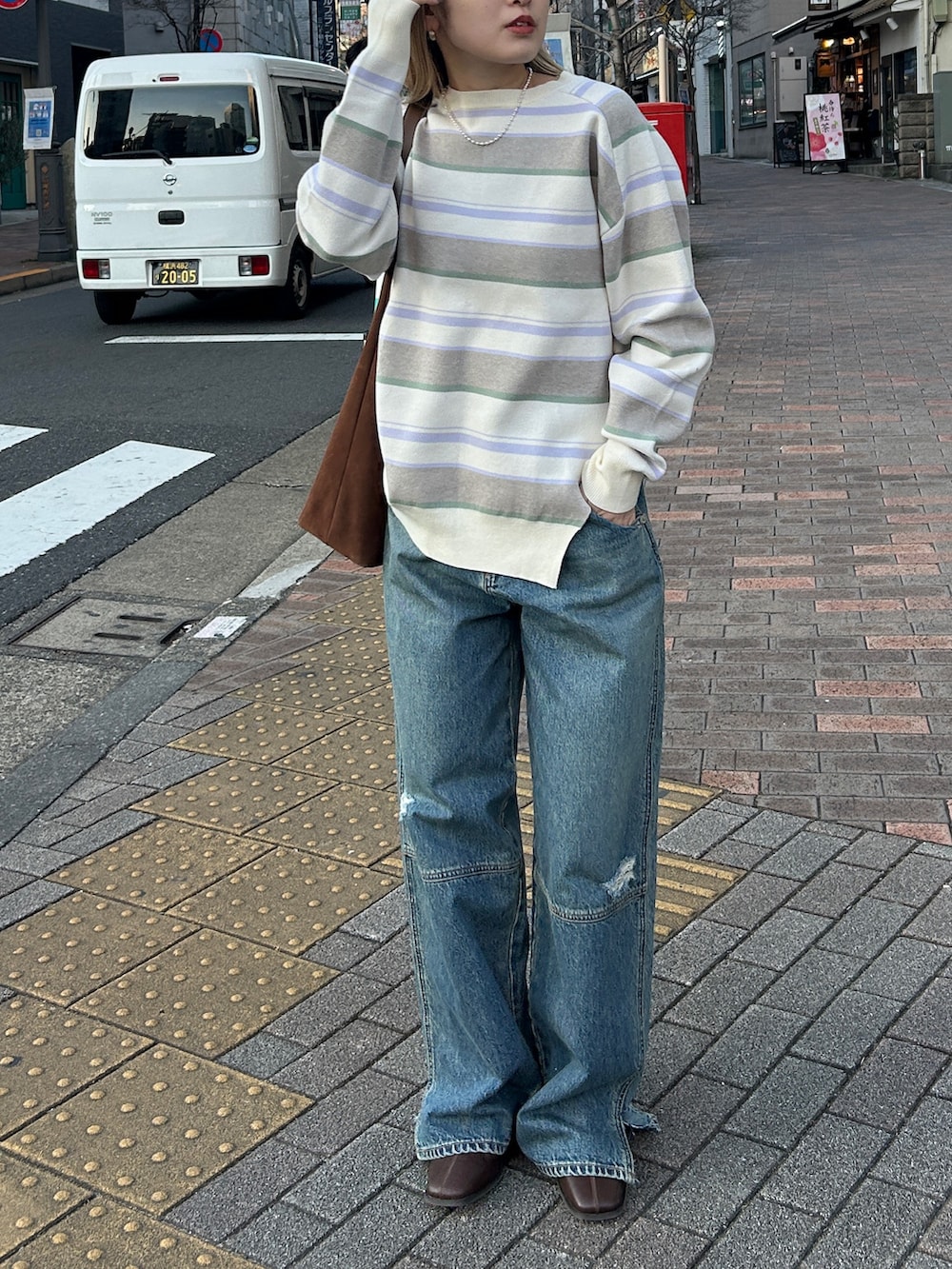 ホワイト系のニット/セーター、ブルー系のデニムパンツを着用したレディースの春コーディネートの2枚目の写真