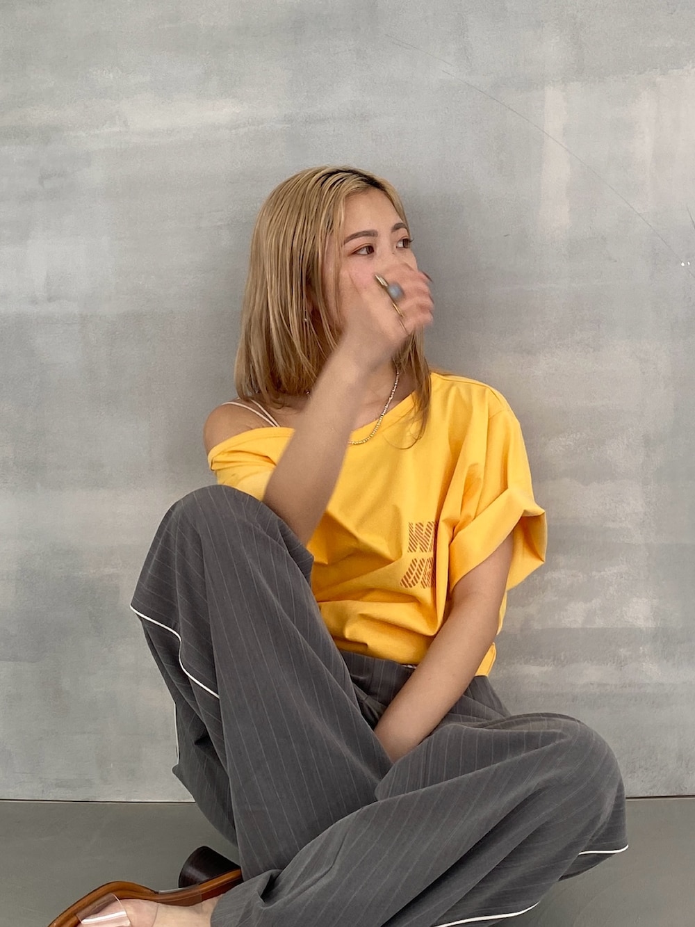 グレー系のその他パンツ、イエロー系のTシャツ/カットソー、ホワイト系のキャミソールを着用したレディースの春コーディネートの3枚目の写真