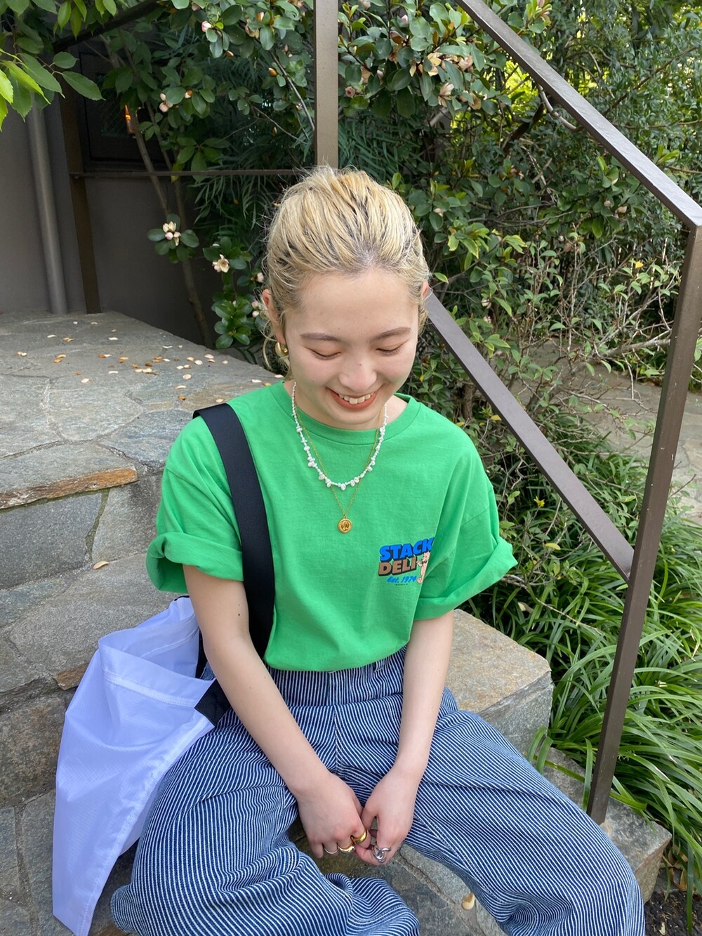 グリーン系のTシャツ/カットソー、その他のデニムパンツ、ホワイト系のハンドバッグを着用したレディースの春コーディネートの2枚目の写真