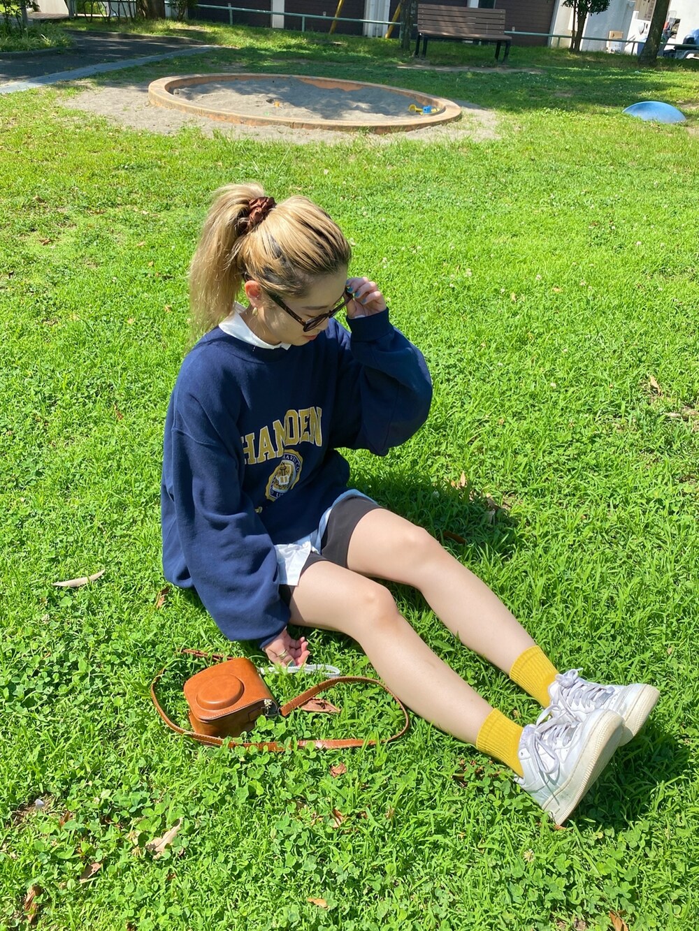 ブルー系のスウェット、ホワイト系のシャツ/ブラウス、ブラウン系のメガネを着用したレディースの夏コーディネートの2枚目の写真