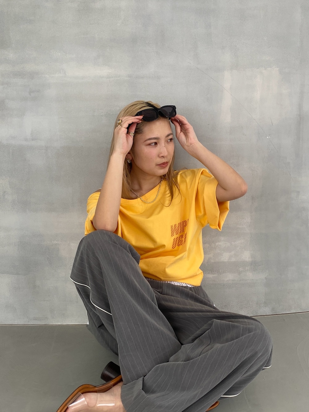 グレー系のその他パンツ、イエロー系のTシャツ/カットソー、ホワイト系のキャミソールを着用したレディースの春コーディネートの2枚目の写真