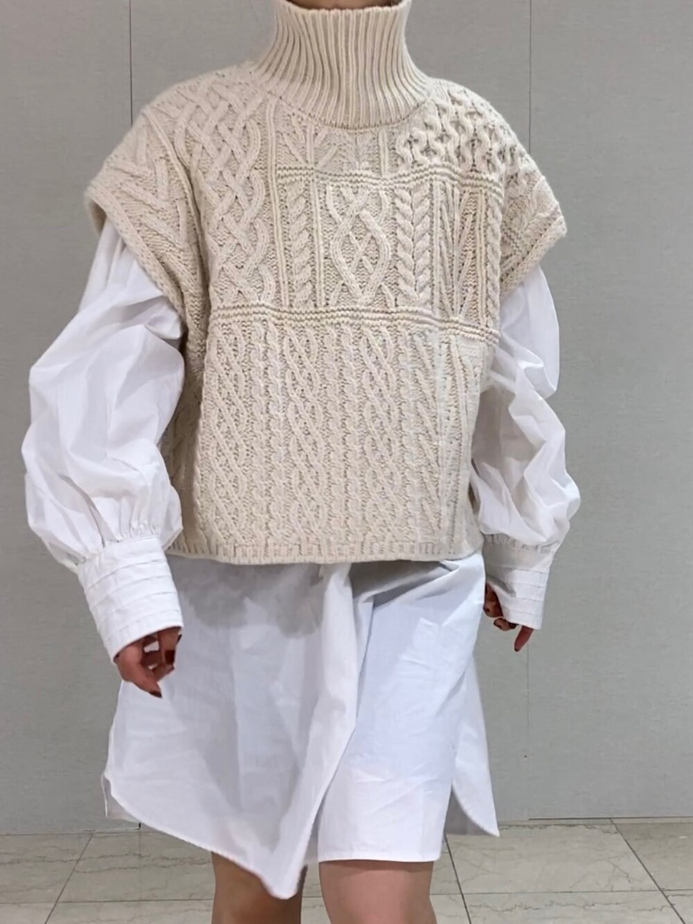 ホワイト系のシャツ/ブラウス、ホワイト系のニット/セーター、ブラック系のブーツを着用したレディースの秋コーディネートの5枚目の写真