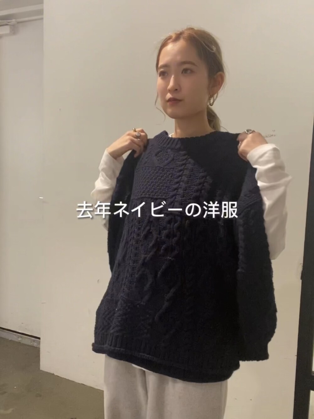 ブルー系のニット/セーター、ホワイト系のTシャツ/カットソー、グレー系のその他パンツを着用したレディースの冬コーディネートの4枚目の写真