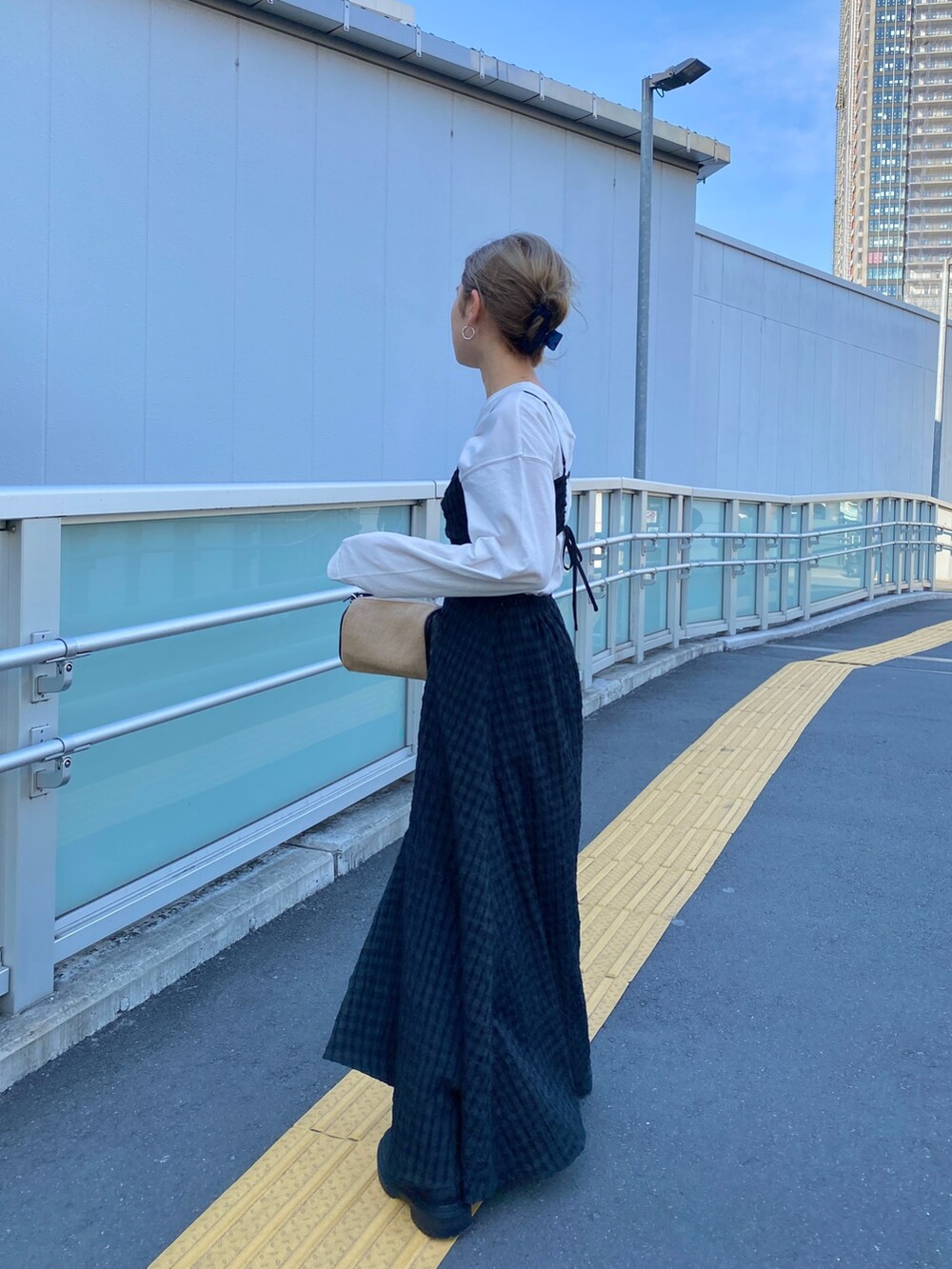 ホワイト系のTシャツ/カットソー、ブラック系のワンピース、ブラック系のブーツを着用したレディースの冬コーディネートの2枚目の写真