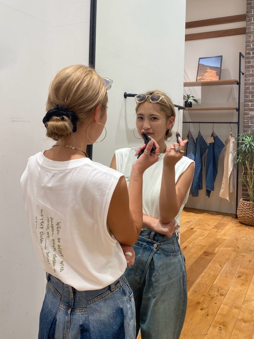 ホワイト系のタンクトップ、ブルー系のデニムパンツを着用したレディースの夏コーディネートの3枚目の写真