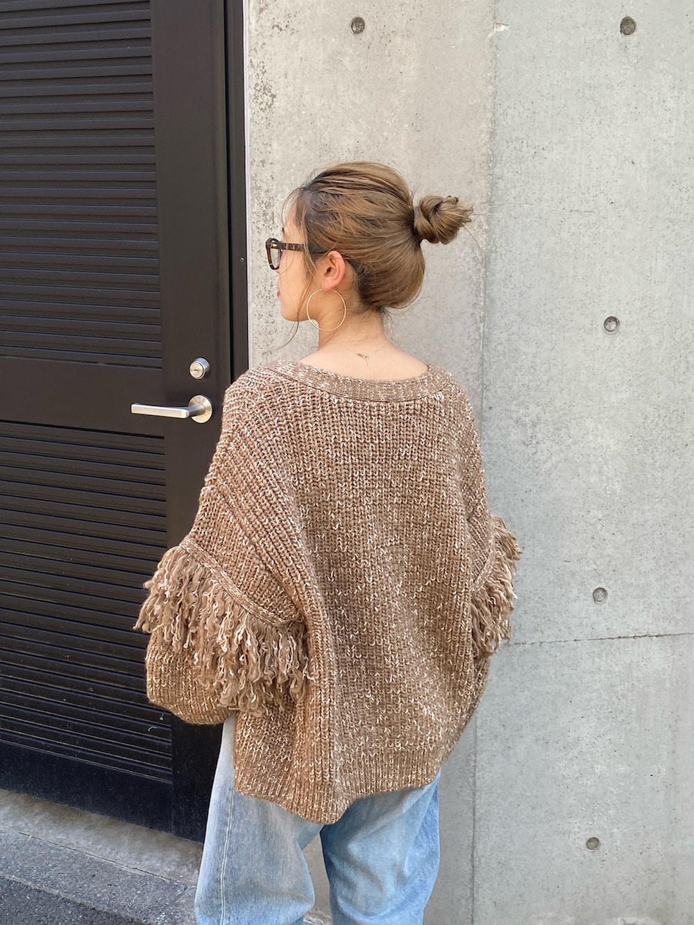 ブラウン系のカーディガン/ボレロ、ブルー系のデニムパンツ、ブラウン系のブーツを着用したレディースの冬コーディネートの4枚目の写真