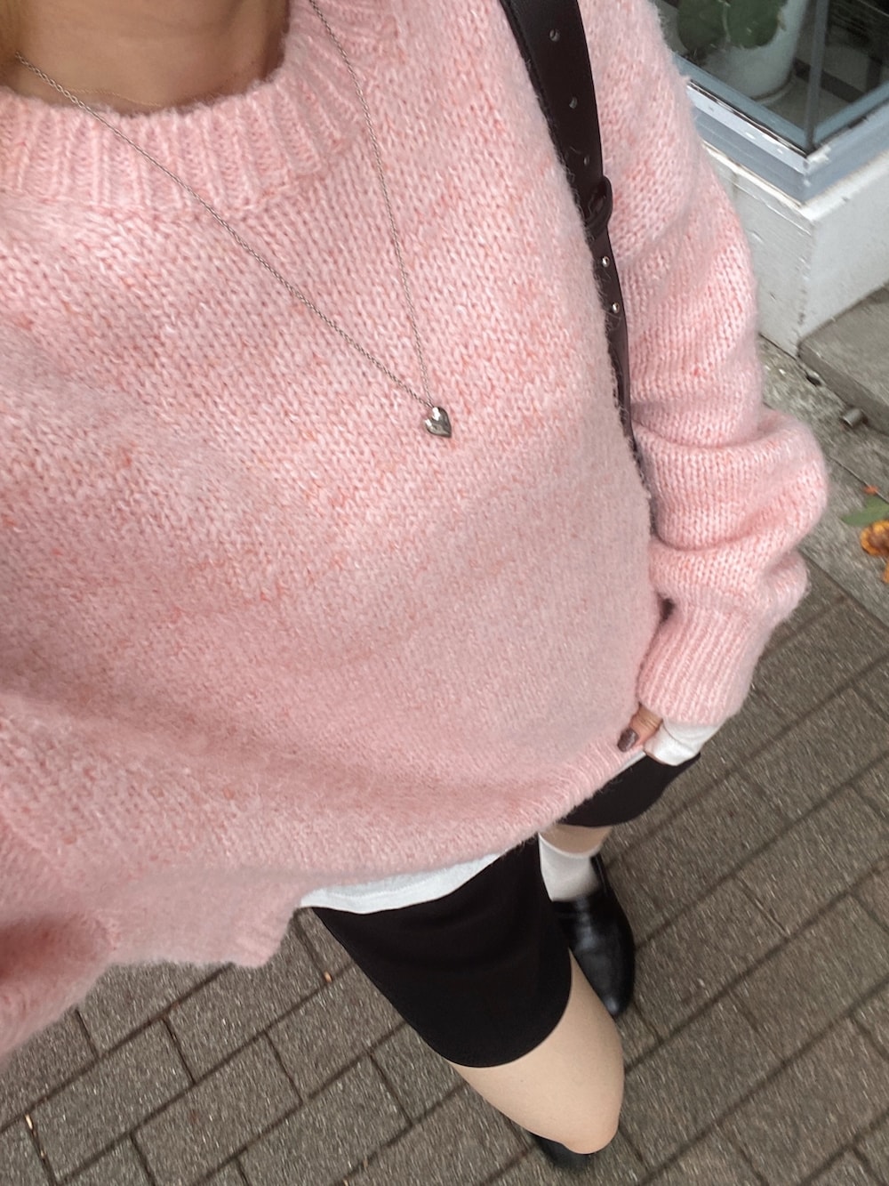 ピンク系のニット/セーター、ブラック系のローファー、ブラック系のショルダーバッグを着用したレディースの秋コーディネートの6枚目の写真