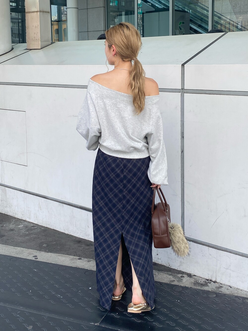 グレー系のスウェット、ブルー系のスカート、ゴールド系のバレエシューズを着用したレディースの夏コーディネートの2枚目の写真