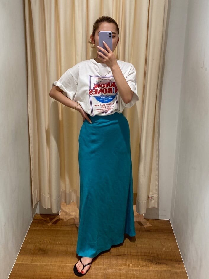 ブルー系のスカート、ホワイト系のTシャツ/カットソーを着用したレディースの夏コーディネートの2枚目の写真