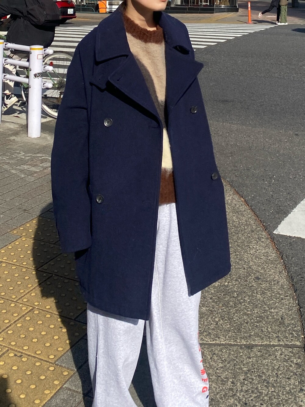ブルー系のその他アウター、グレー系のニット/セーター、グレー系のスウェットパンツを着用したレディースの冬コーディネートの4枚目の写真