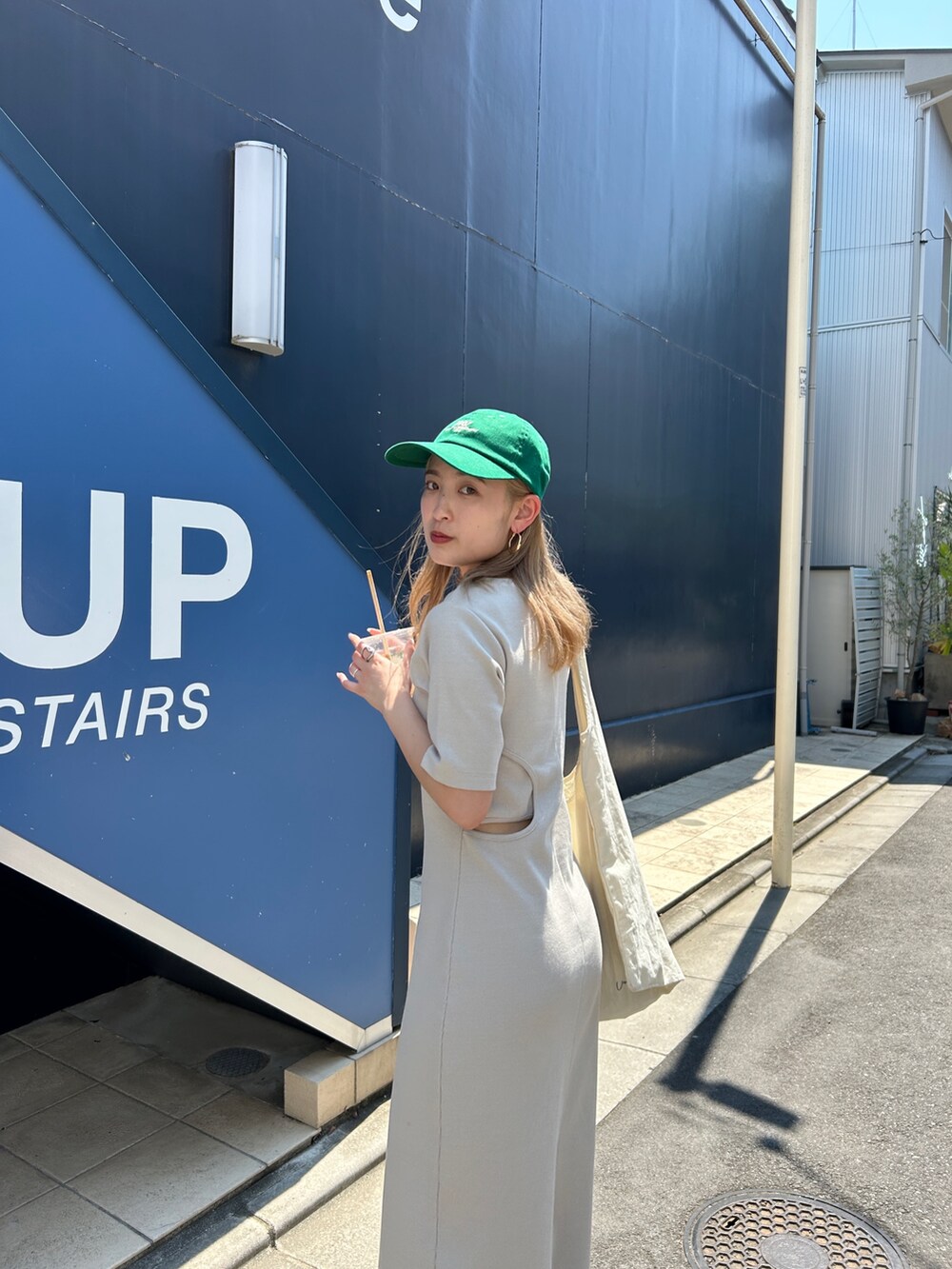 グレー系のワンピース、グリーン系のキャップを着用したレディースの夏コーディネートの8枚目の写真