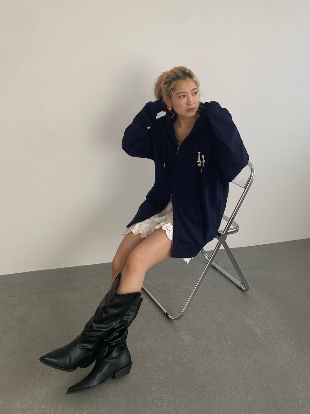 ブルー系のパーカー、ホワイト系のその他パンツ、ブラック系のブーツを着用したレディースの春コーディネートの4枚目の写真