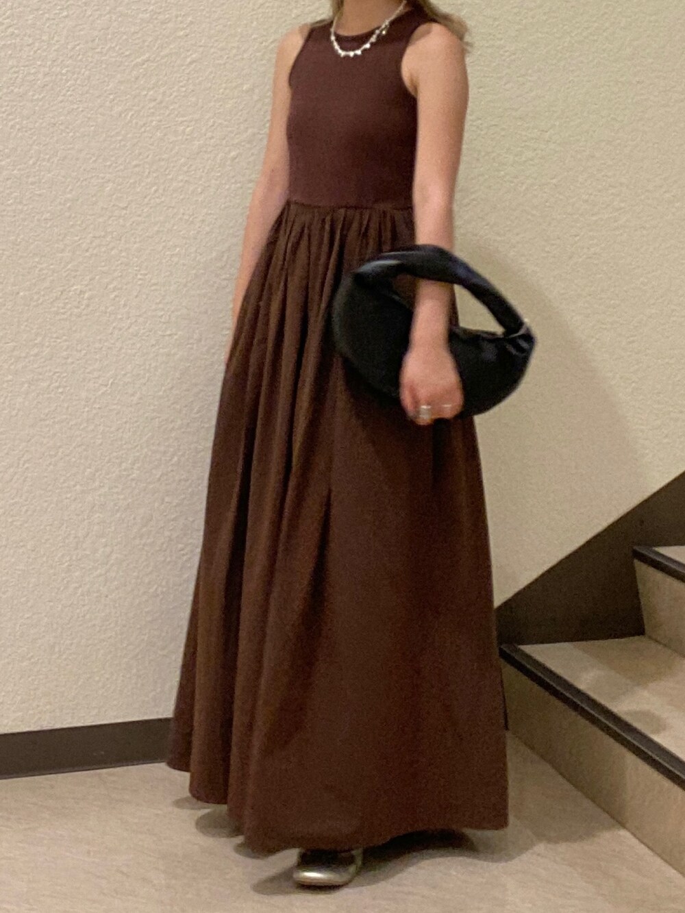 ブラック系のハンドバッグ、ブラウン系のワンピース、ベージュ系のハットを着用したレディースの夏コーディネートの3枚目の写真