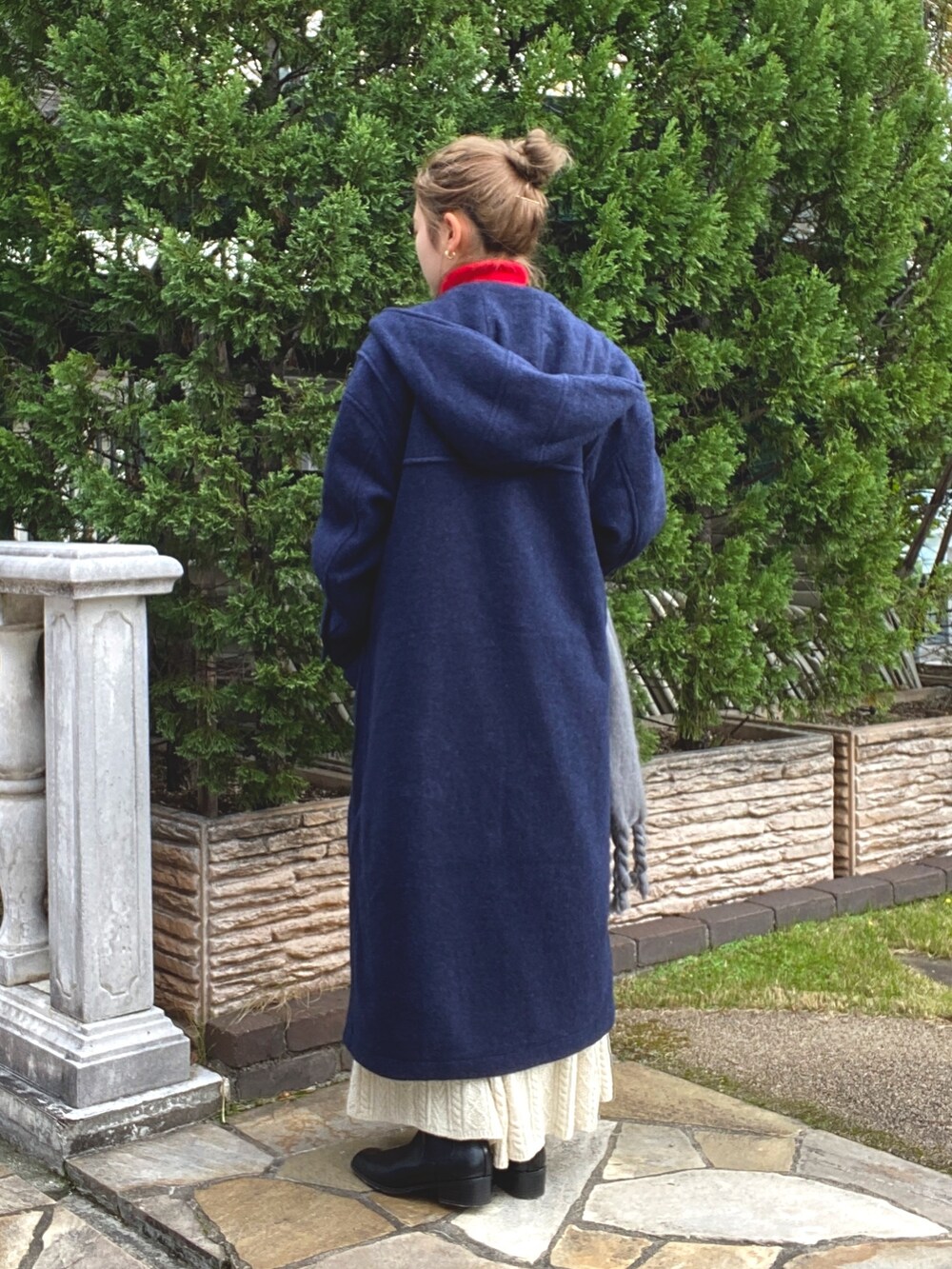 ホワイト系のスカート、ブルー系のダッフルコート、レッド系のニット/セーターを着用したレディースの冬コーディネートの4枚目の写真