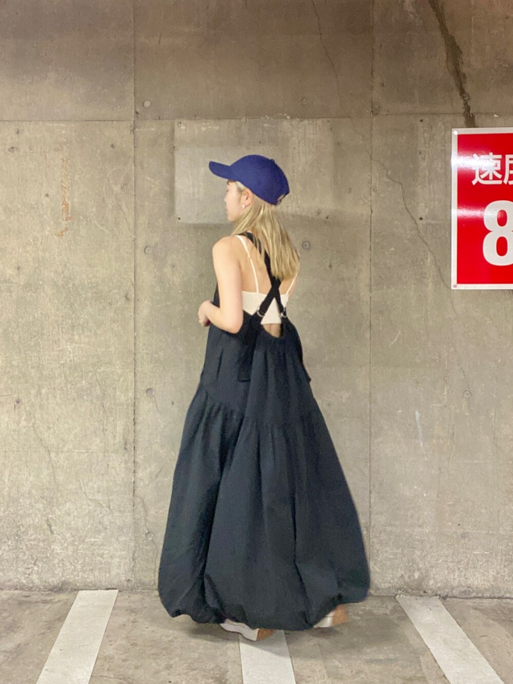 ホワイト系のキャミソール、ブラック系のワンピース、ブルー系のキャップを着用したレディースの春コーディネートの4枚目の写真
