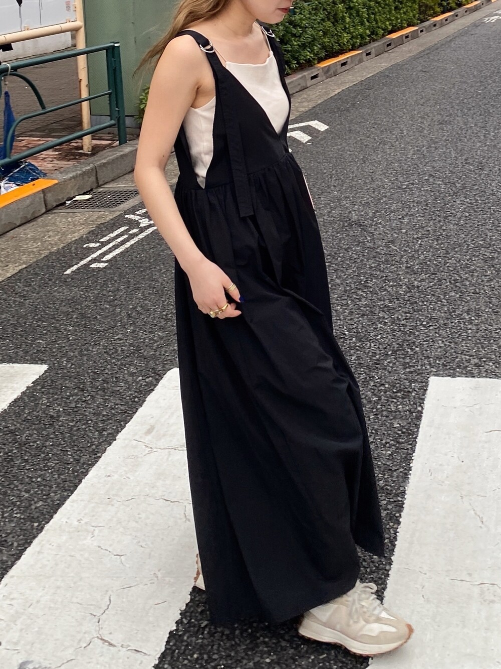 ブラック系のワンピース、ホワイト系のキャミソール、グリーン系のキャップを着用したレディースの春コーディネートの2枚目の写真