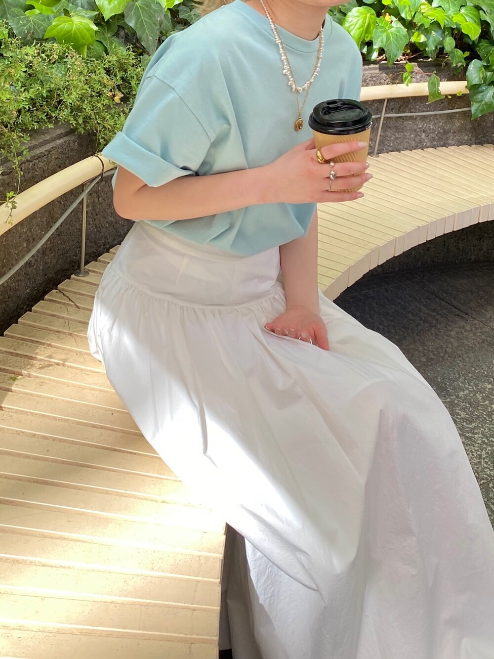 ブルー系のTシャツ/カットソー、ホワイト系のスカートを着用したレディースの春コーディネートの6枚目の写真