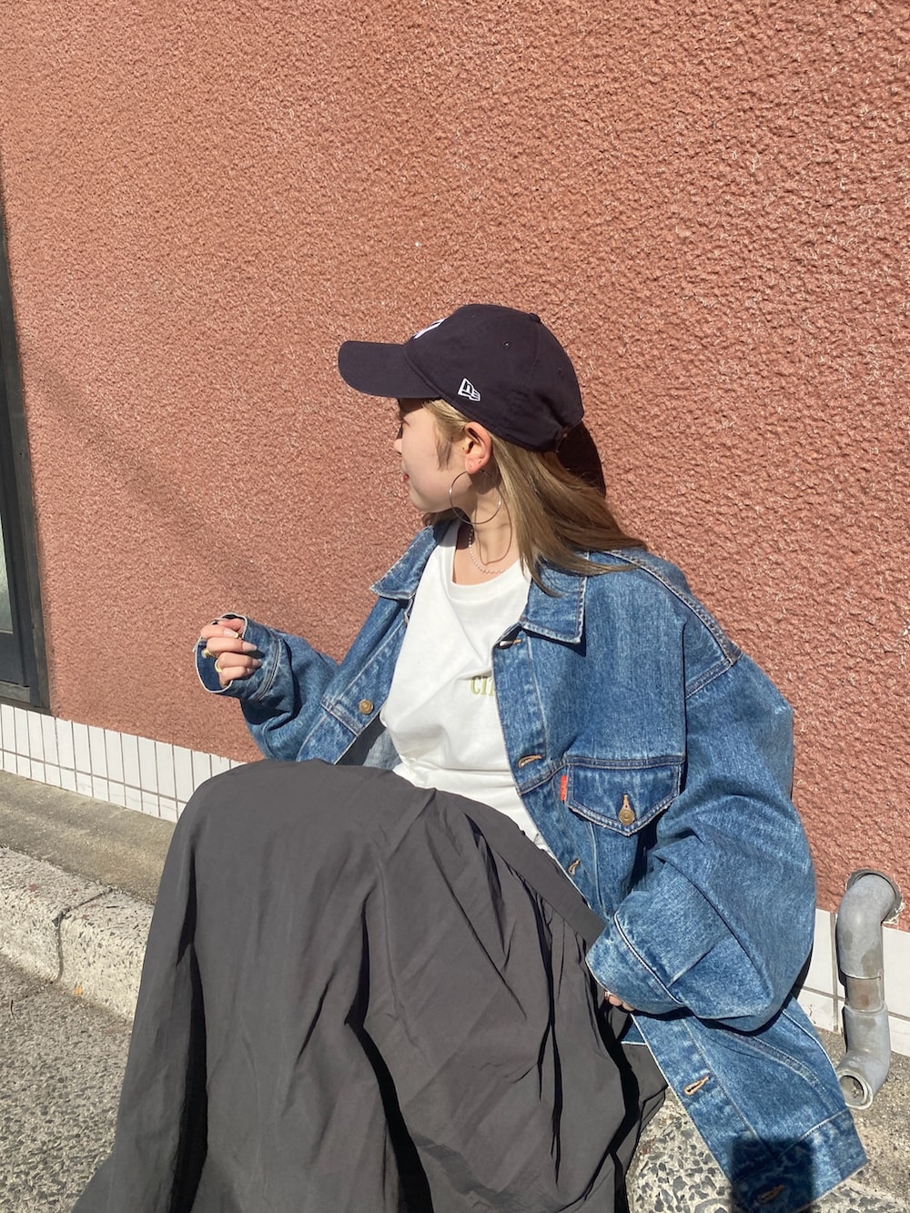 ホワイト系のTシャツ/カットソー、ブルー系のデニムジャケット、グレー系のスカートを着用したレディースの春コーディネートの3枚目の写真