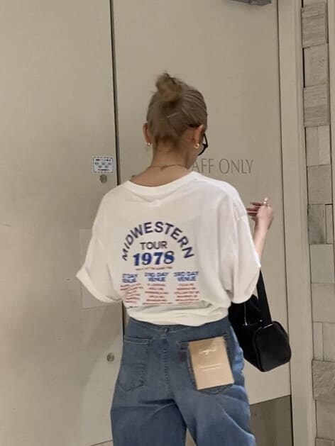 ブルー系のデニムパンツ、ホワイト系のTシャツ/カットソー、ブラック系のサンダルを着用したレディースの夏コーディネートの4枚目の写真