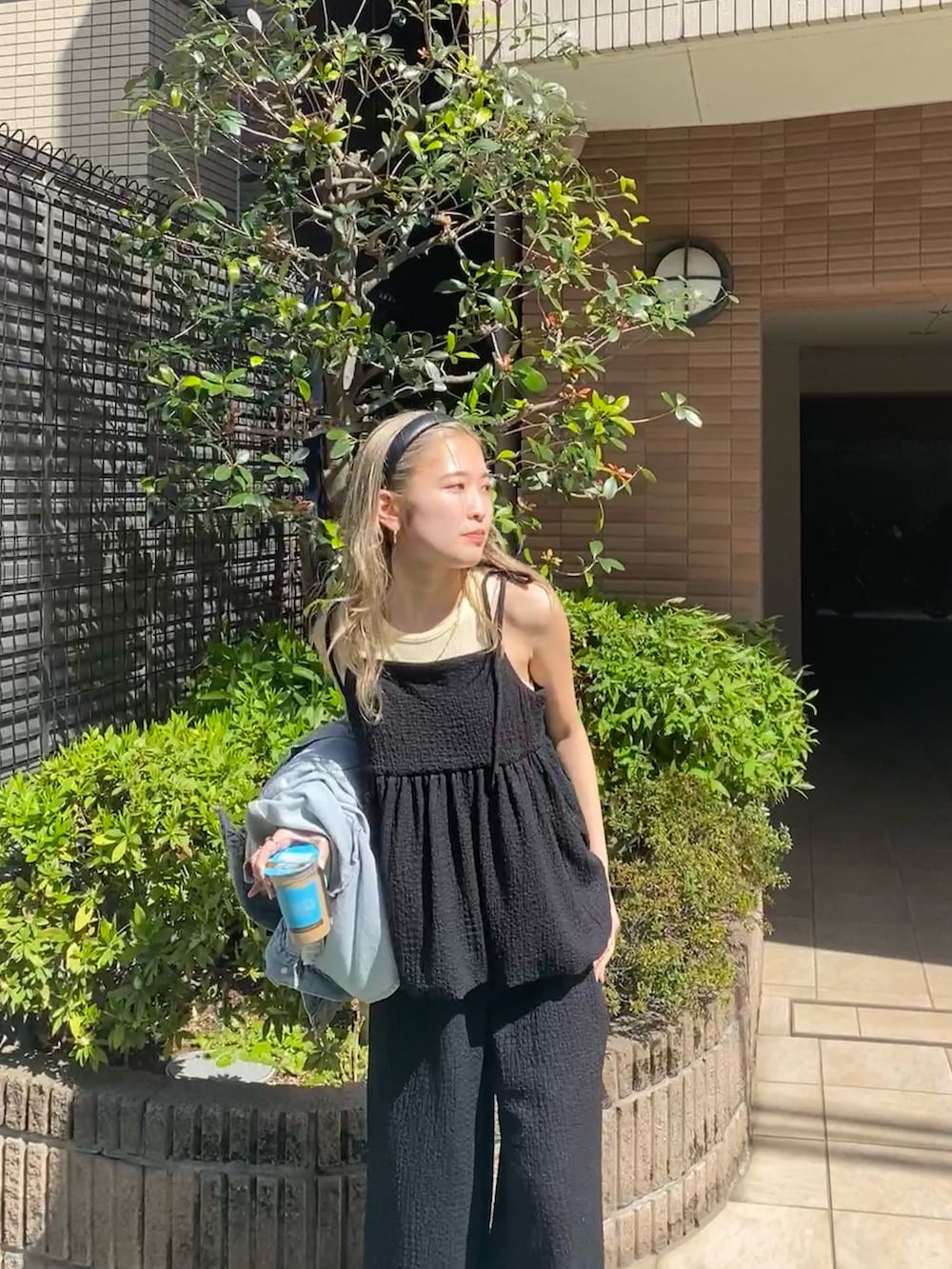 ブラック系のワンピース、イエロー系のタンクトップを着用したレディースの夏コーディネートの5枚目の写真