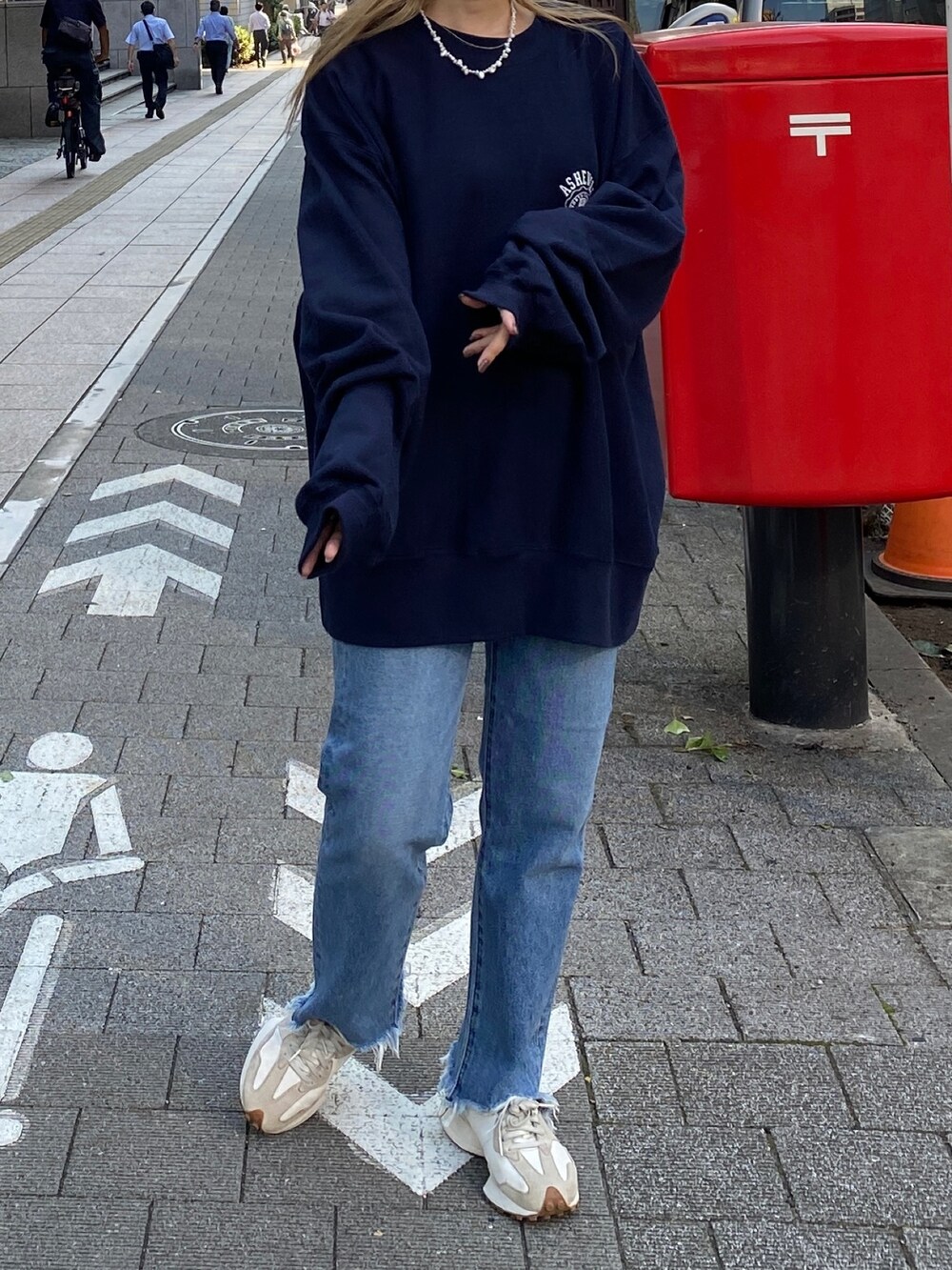 ブルー系のスウェット、ブルー系のデニムパンツ、ホワイト系のニットキャップ/ビーニーを着用したレディースの秋コーディネートの5枚目の写真