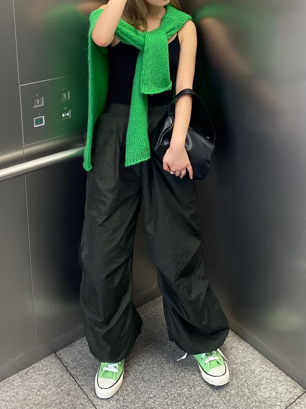 グリーン系のニット/セーター、グレー系のその他パンツを着用したレディースの秋コーディネートの2枚目の写真