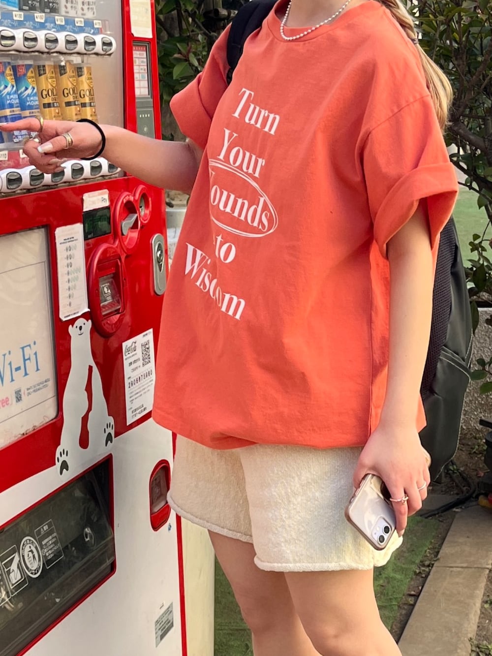 オレンジ系のTシャツ/カットソー、ホワイト系のその他パンツ、ブラック系のメガネを着用したレディースの夏コーディネートの4枚目の写真