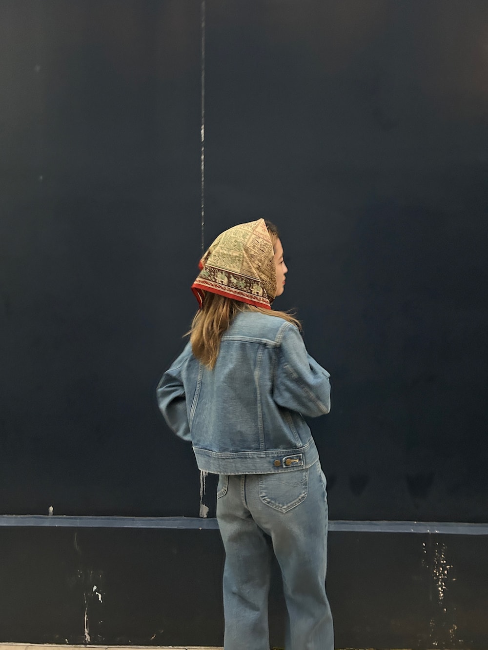 ブルー系のデニムジャケット、ブルー系のデニムパンツを着用したレディースの秋コーディネートの2枚目の写真