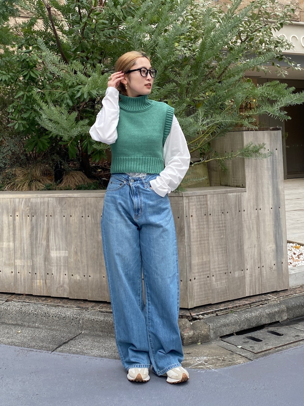 ブルー系のデニムパンツ、グリーン系のワンピースを着用したレディースの冬コーディネートの3枚目の写真