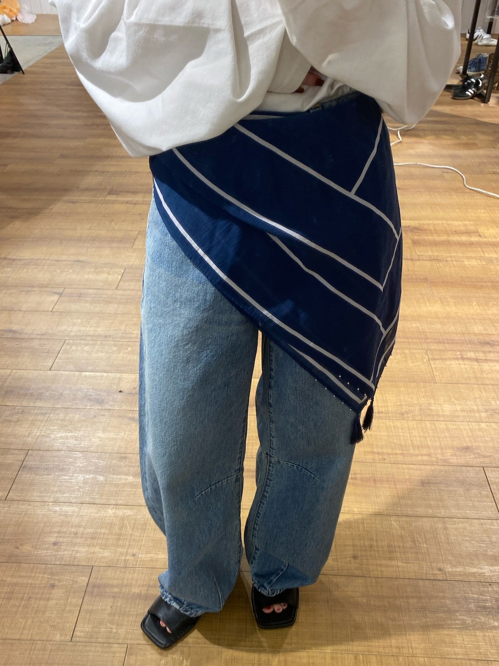 ホワイト系のTシャツ/カットソー、ブルー系のデニムパンツ、ベージュ系のショルダーバッグを着用したレディースの春コーディネートの5枚目の写真