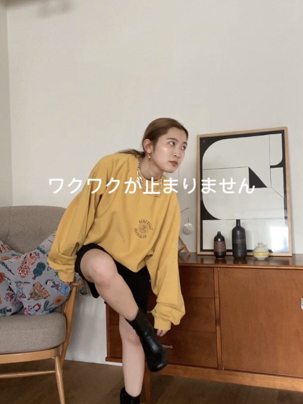 イエロー系のスウェット、ブラック系のニットキャップ/ビーニー、ブラウン系のメガネを着用したレディースの冬コーディネートの3枚目の写真